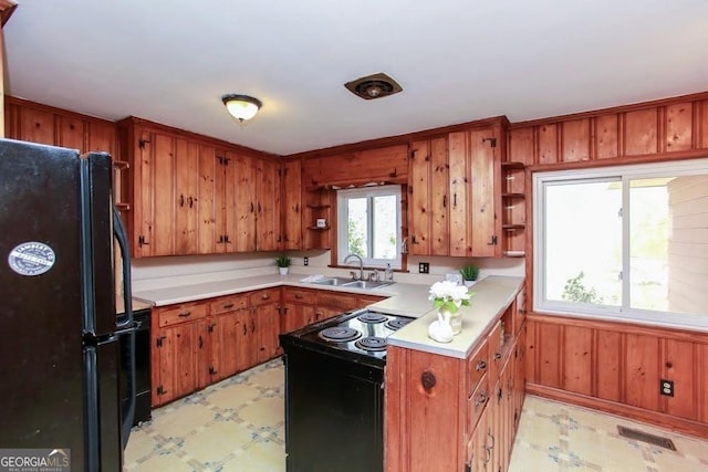 kitchen featuring light floors, light countertops, black appliances, open shelves, and a sink