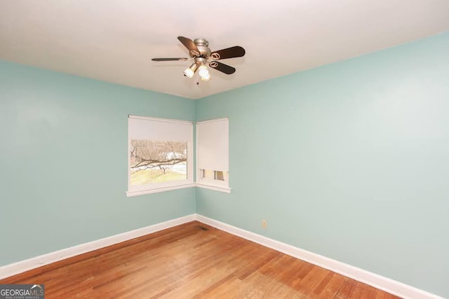 spare room with ceiling fan, light wood finished floors, and baseboards