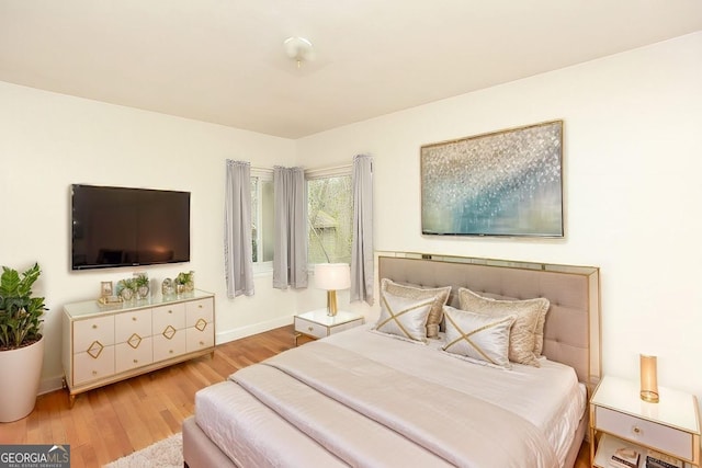 bedroom with baseboards and wood finished floors