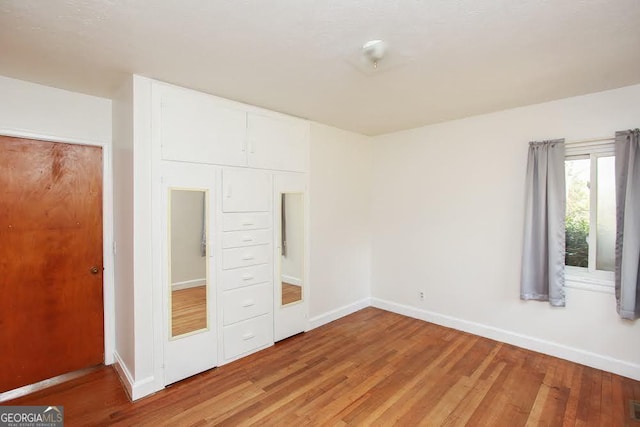 unfurnished bedroom featuring baseboards, visible vents, and light wood-style floors