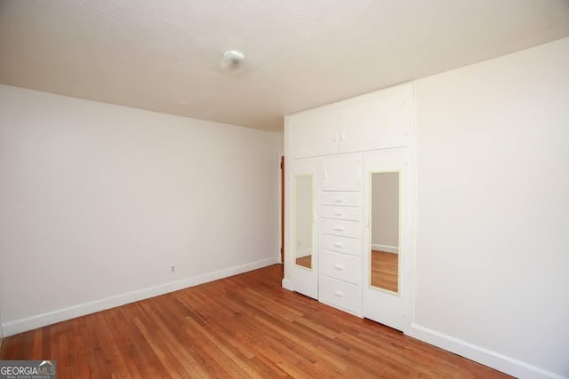 unfurnished bedroom featuring light wood-style flooring and baseboards