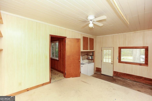 spare room with crown molding, baseboards, a ceiling fan, and independent washer and dryer