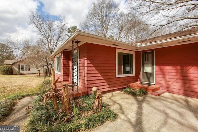 property entrance with a lawn