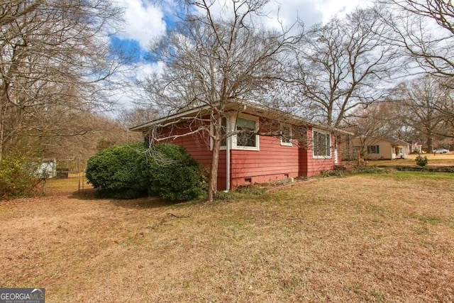 view of side of home with crawl space and a lawn