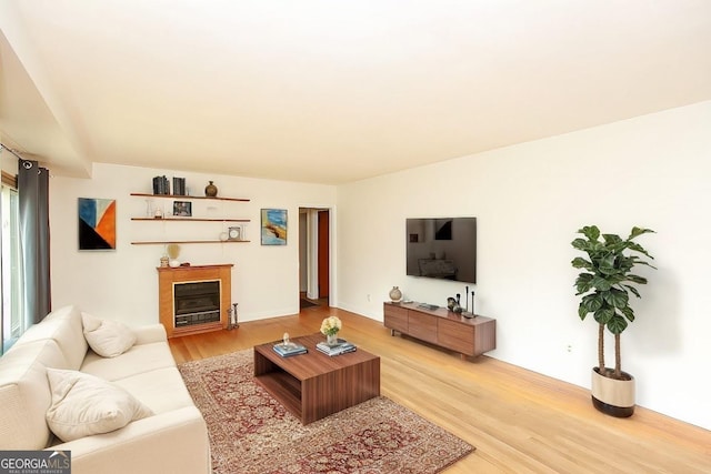 living area with light wood-style flooring and a fireplace