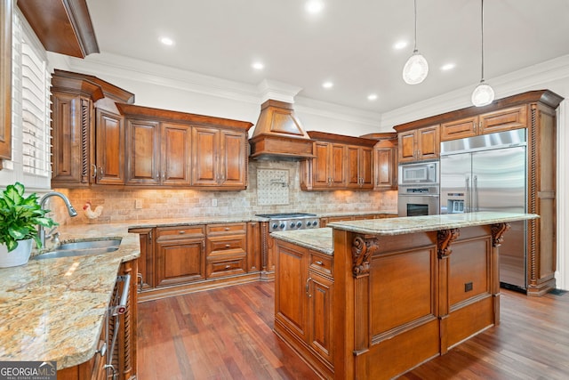 kitchen featuring brown cabinets, a sink, custom exhaust hood, and built in appliances