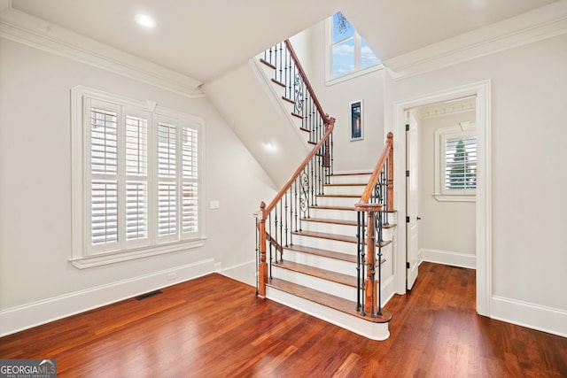 staircase featuring visible vents, baseboards, wood finished floors, crown molding, and recessed lighting