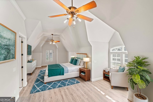 bedroom with vaulted ceiling, multiple windows, light wood-type flooring, and baseboards