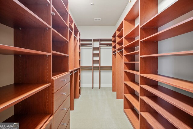 walk in closet featuring light carpet and visible vents