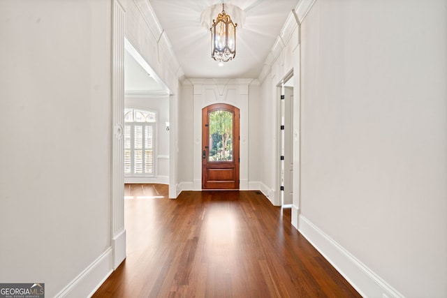 entryway with baseboards, ornamental molding, dark wood finished floors, and a notable chandelier