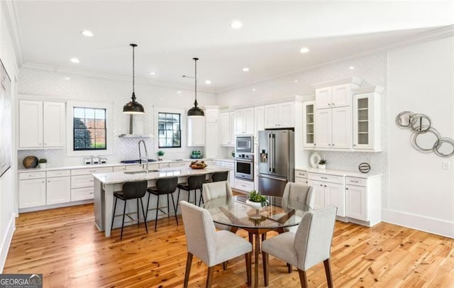 dining space featuring baseboards, ornamental molding, light wood-type flooring, and recessed lighting