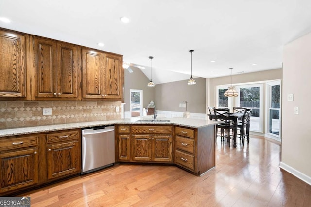 kitchen featuring a sink, light stone counters, tasteful backsplash, a peninsula, and dishwasher