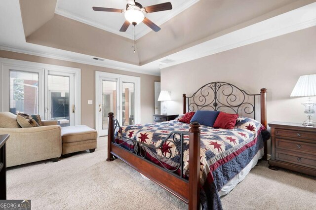 bedroom with a tray ceiling, carpet flooring, and visible vents