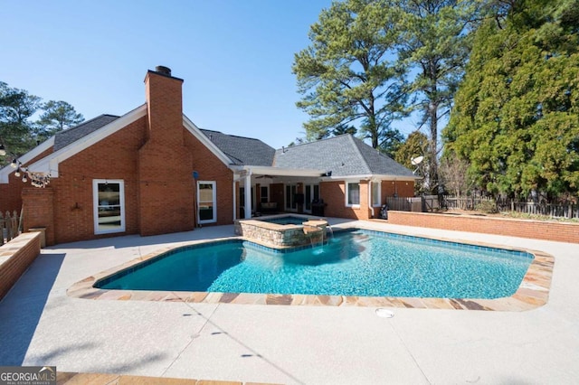 view of pool with a fenced in pool, fence, an in ground hot tub, and a patio area