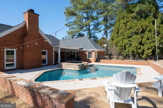 view of pool featuring a patio, fence, and a pool with connected hot tub