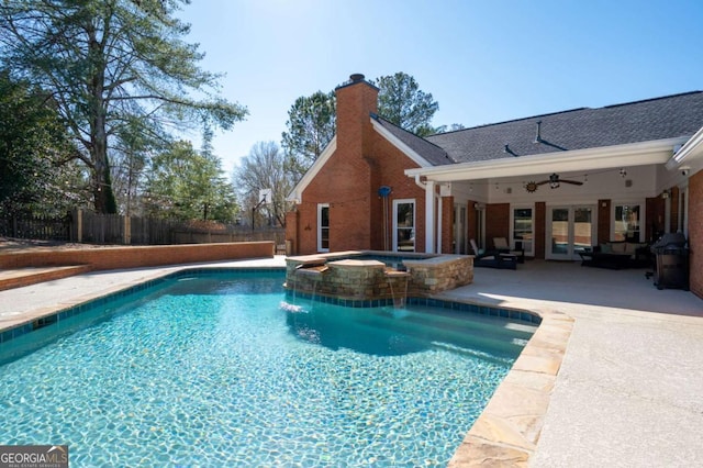 view of pool featuring a patio, a ceiling fan, fence, a pool with connected hot tub, and french doors