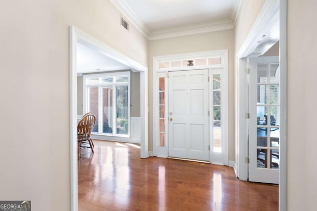 entrance foyer featuring wood finished floors, visible vents, and ornamental molding