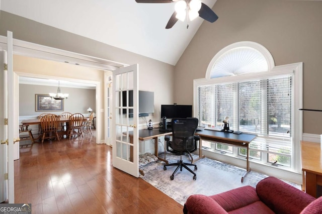 office space with ceiling fan with notable chandelier, wood finished floors, french doors, and high vaulted ceiling