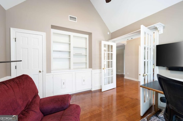 office space featuring built in features, wood finished floors, visible vents, lofted ceiling, and french doors