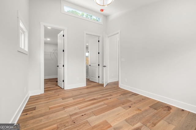 6564 Bermuda Ln, Flowery Branch, GA 30542 - unfurnished bedroom with a spacious closet, light wood-type flooring, baseboards, and a closet