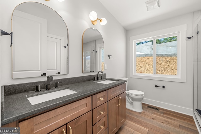 6564 Bermuda Ln, Flowery Branch, GA 30542 - full bathroom with double vanity, lofted ceiling, toilet, wood finished floors, and baseboards