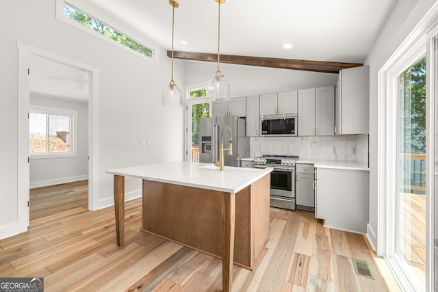 6564 Bermuda Ln, Flowery Branch, GA 30542 - kitchen with stainless steel appliances, gray cabinets, backsplash, light wood-style flooring, and light countertops