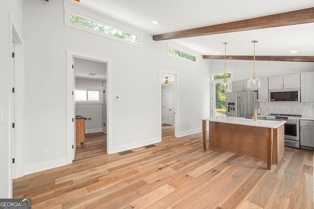 6564 Bermuda Ln, Flowery Branch, GA 30542 - kitchen with stainless steel appliances, light countertops, gray cabinets, decorative backsplash, and light wood-type flooring