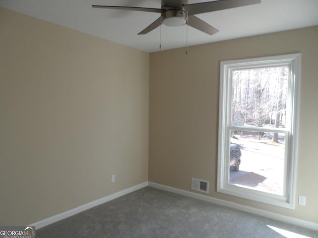 spare room with carpet, visible vents, and baseboards