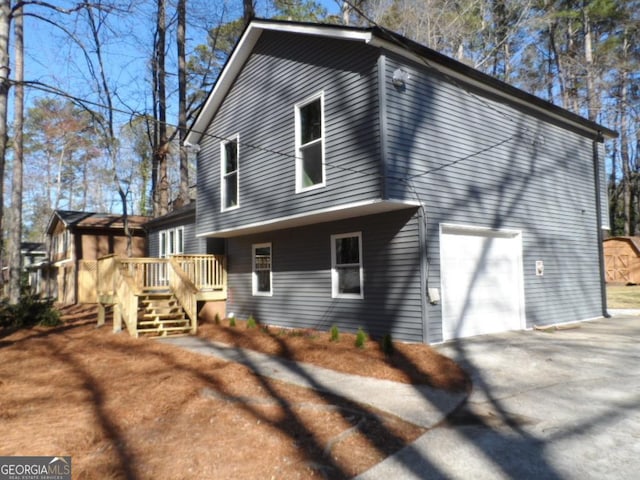 view of side of property featuring a deck and driveway