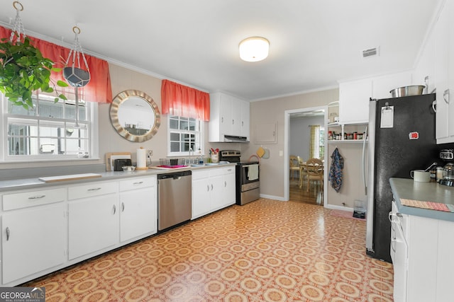 kitchen featuring stainless steel appliances, ornamental molding, and white cabinets