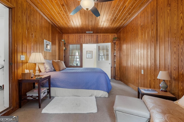 bedroom with wooden walls, wood ceiling, ceiling fan, and carpet