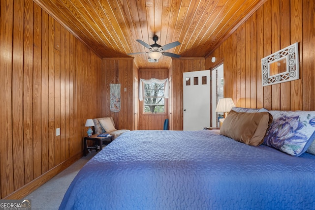 bedroom with carpet floors, wooden walls, wood ceiling, and a ceiling fan