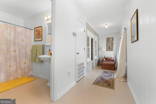 corridor with finished concrete floors and crown molding