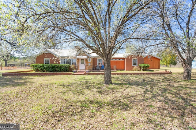 ranch-style house featuring a front yard and brick siding