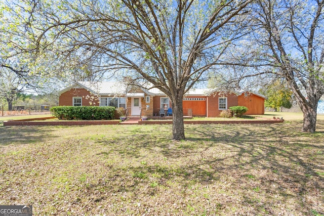 single story home featuring brick siding and a front yard