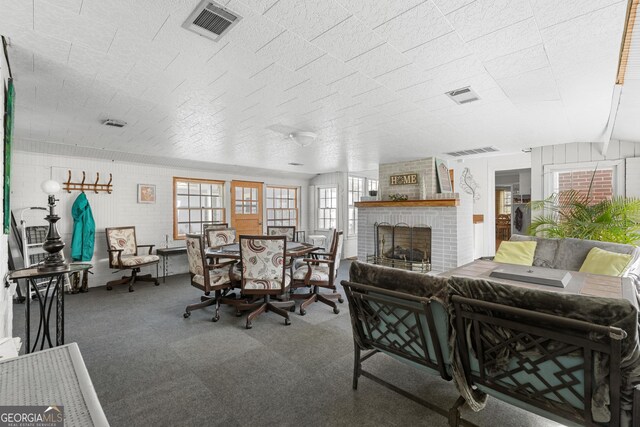 living room featuring a brick fireplace and visible vents