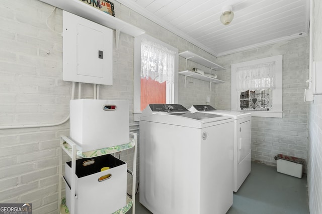 clothes washing area featuring electric panel, ornamental molding, laundry area, and washer and dryer