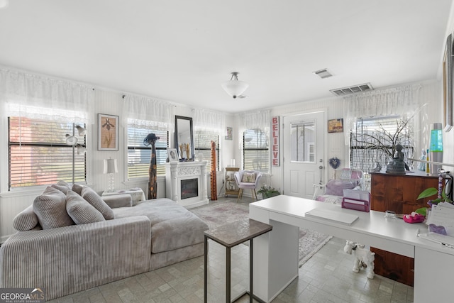 living room featuring visible vents and a glass covered fireplace