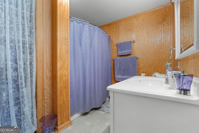 bathroom with tile patterned floors, wooden walls, and vanity