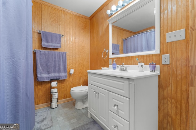 bathroom featuring vanity, toilet, and wood walls