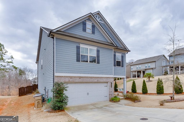 view of front of property with a garage, concrete driveway, brick siding, and fence