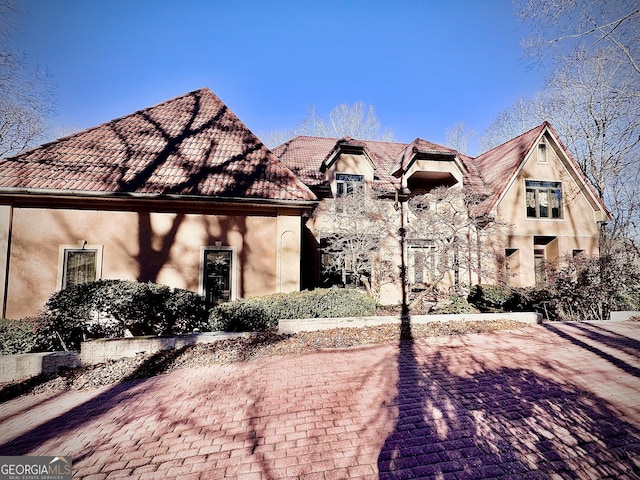 view of front of home featuring stucco siding and a tiled roof