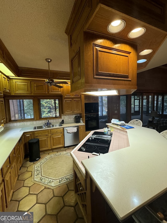 kitchen with black oven, stainless steel dishwasher, a sink, and light countertops