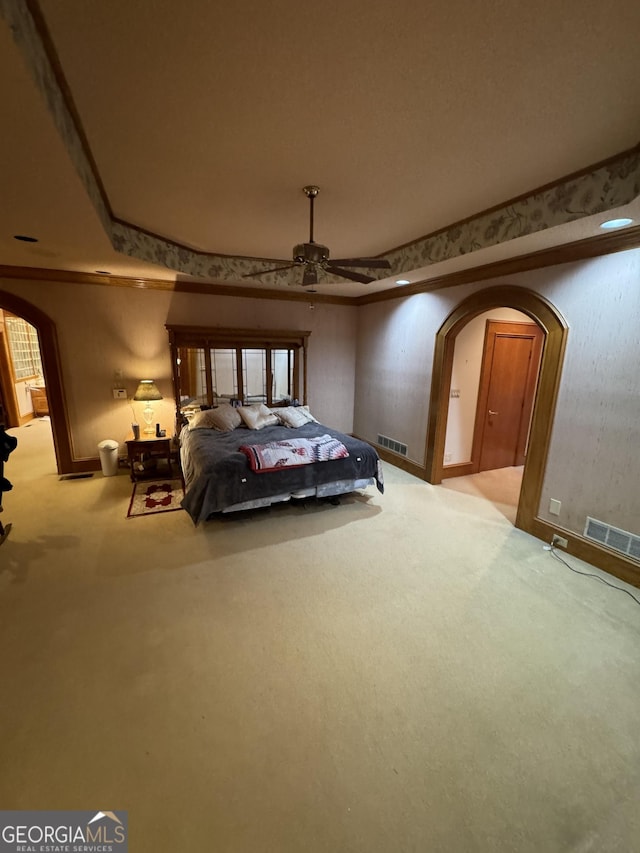 bedroom with arched walkways, light colored carpet, and visible vents