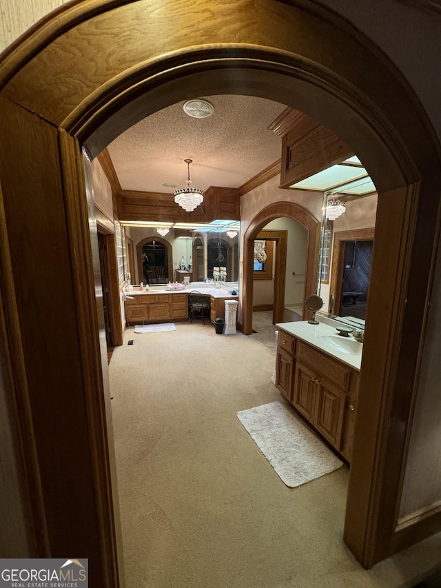 bathroom with ornamental molding, a chandelier, a textured ceiling, and vanity