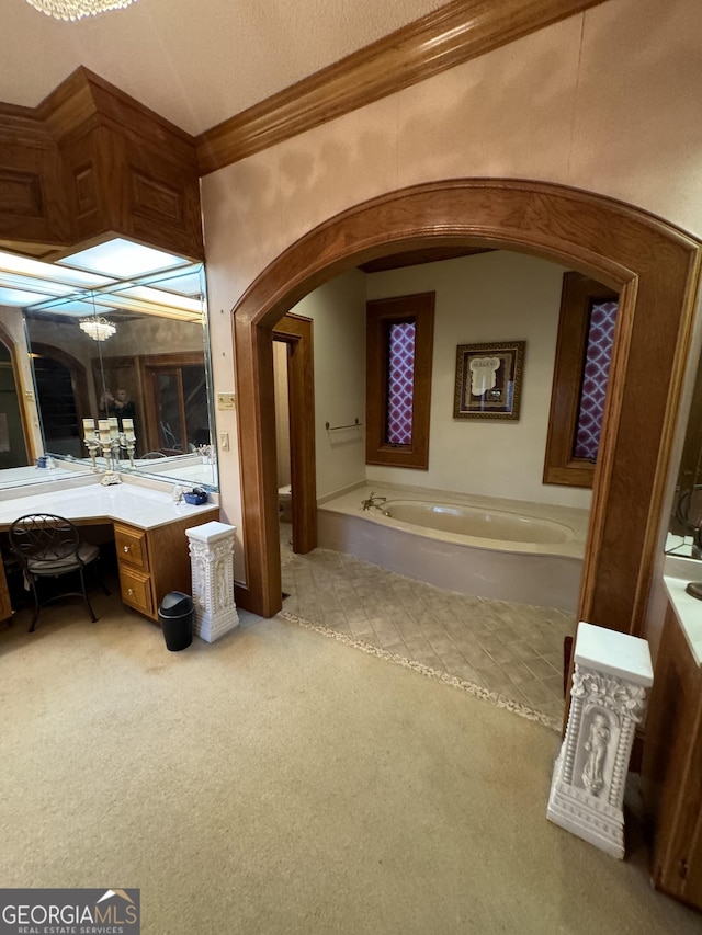 bathroom with ornamental molding, a garden tub, vanity, and toilet