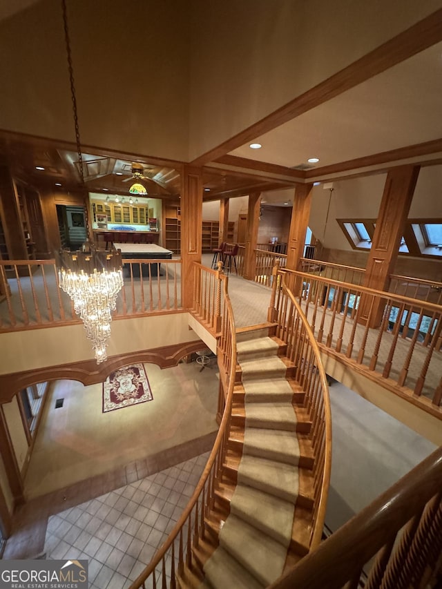 interior space with ceiling fan with notable chandelier, a skylight, a towering ceiling, and recessed lighting