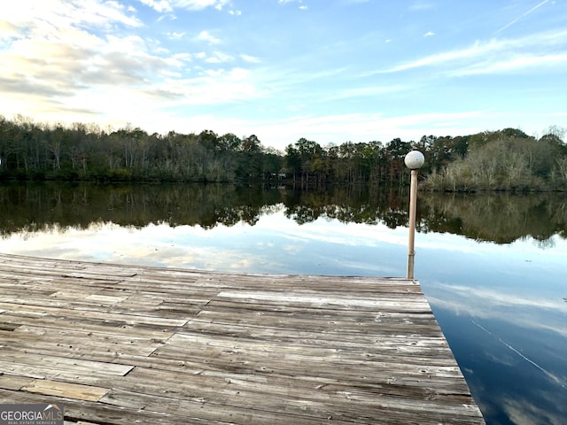 view of dock featuring a water view and a wooded view