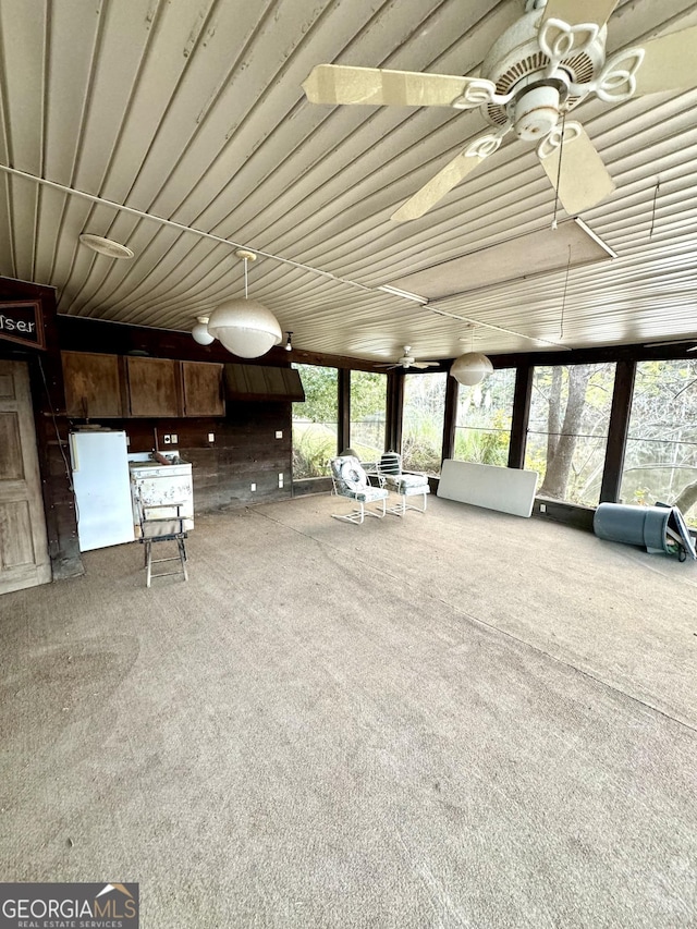 unfurnished sunroom with ceiling fan