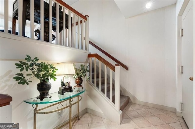 stairway with baseboards and tile patterned floors